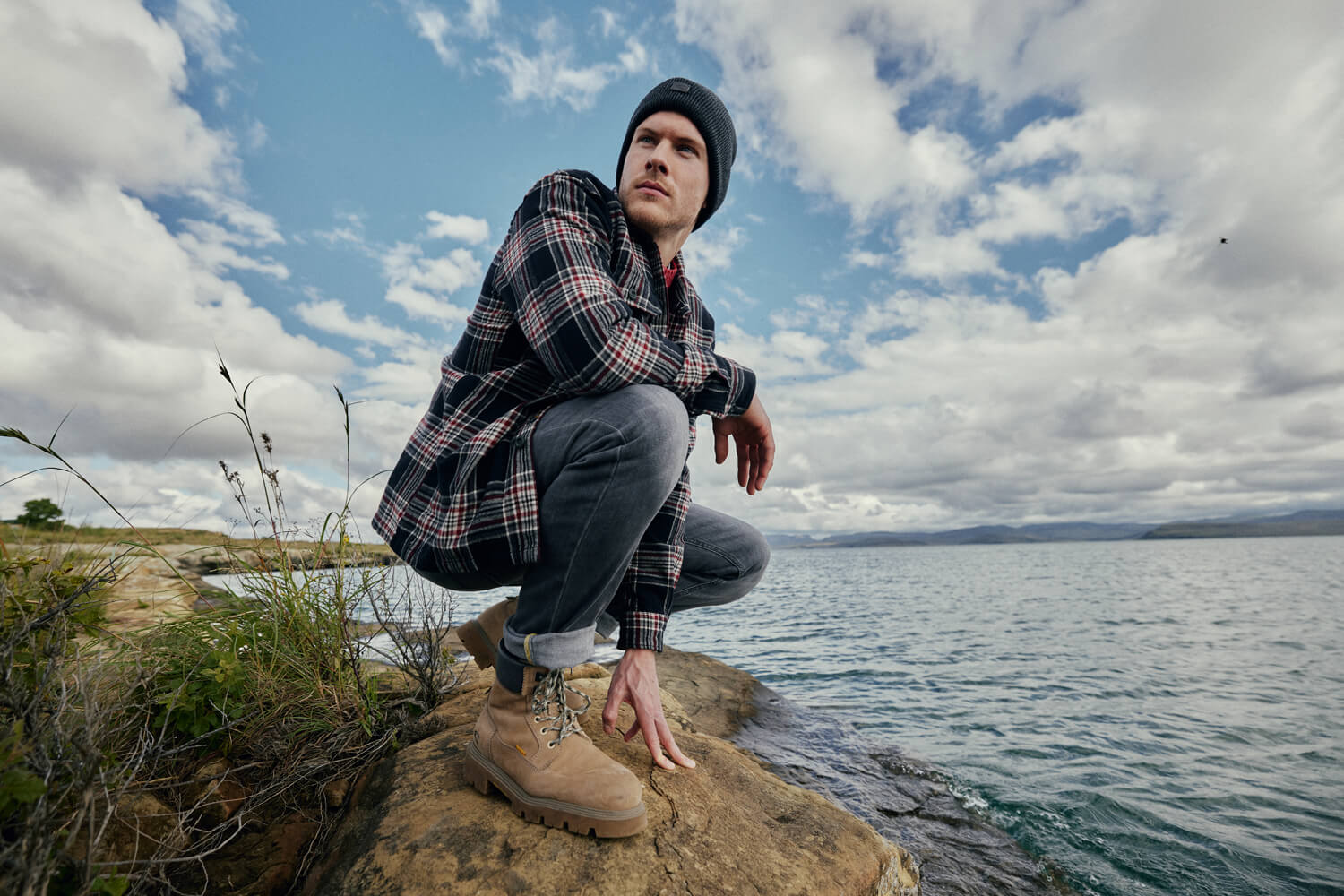 camel active - CAMEL ACTIVE BOOTS: DIE RICHTIGEN BEGLEITER FÜR JEDES ABENTEUER - camel active - CAMEL ACTIVE BOOTS: DIE RICHTIGEN BEGLEITER FÜR JEDES ABENTEUER - Mann an der Küste mit Meer im Hintergrund